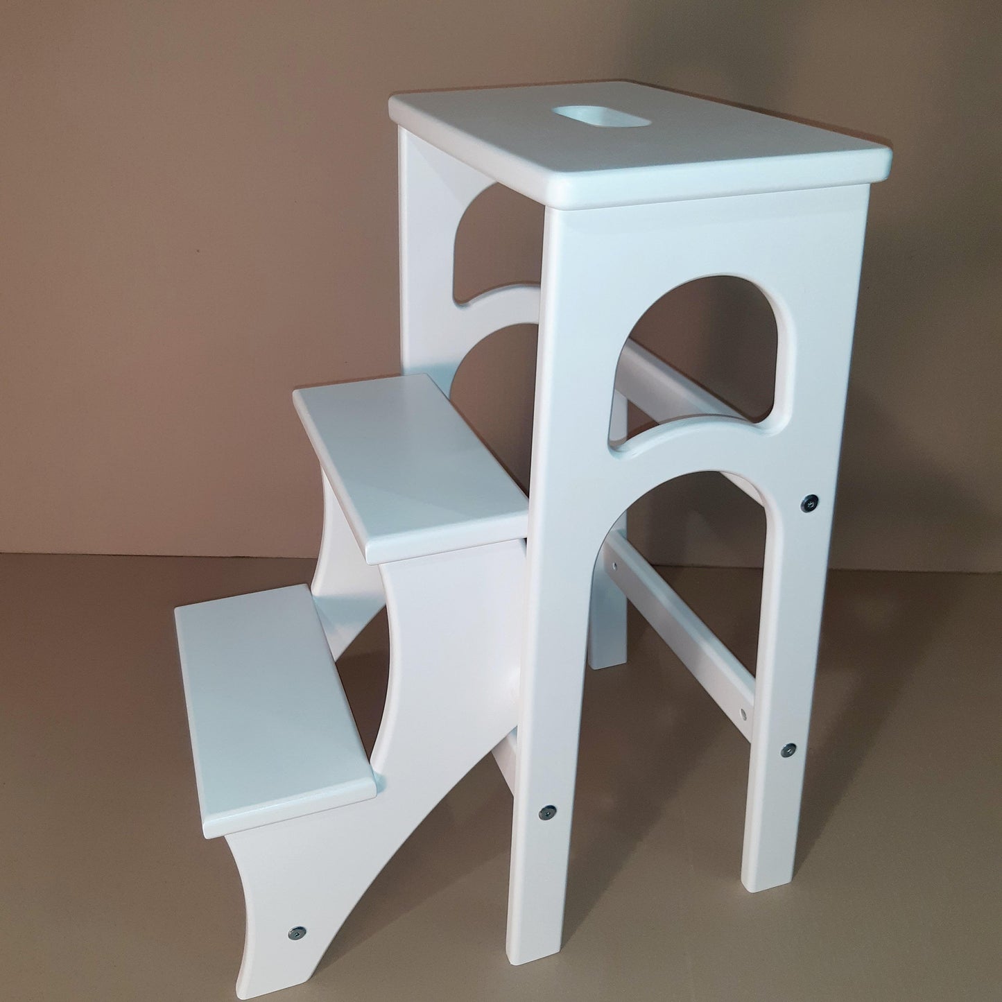 This is a step stool with three steps in white. It transforms easily and quickly.
